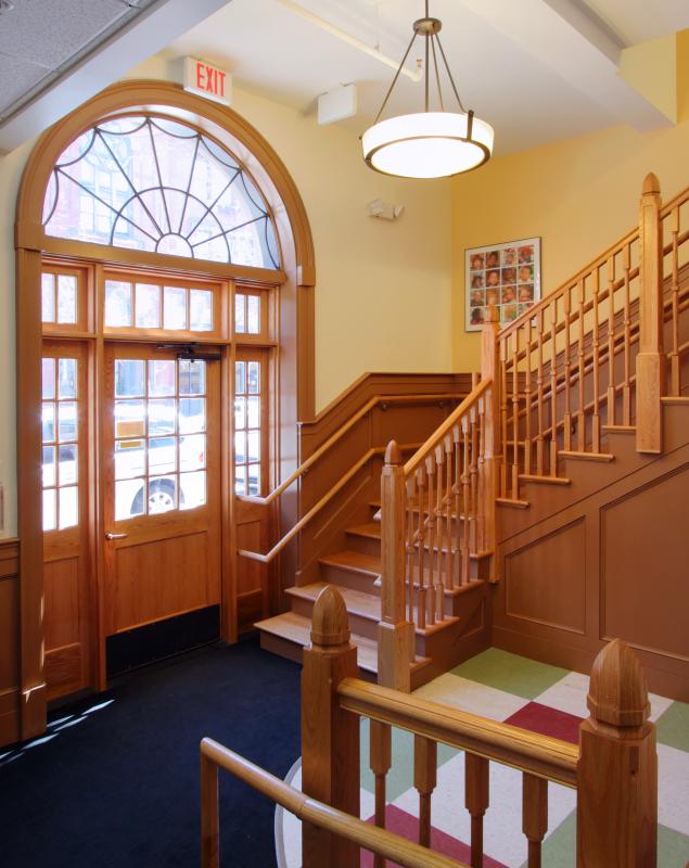 Lobby interior with arched doorway and wooden staircase