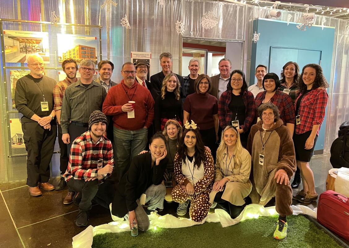 DSA group photo at 2022 holiday party, with a lumberjack theme. Mike is wearing a bear costume.