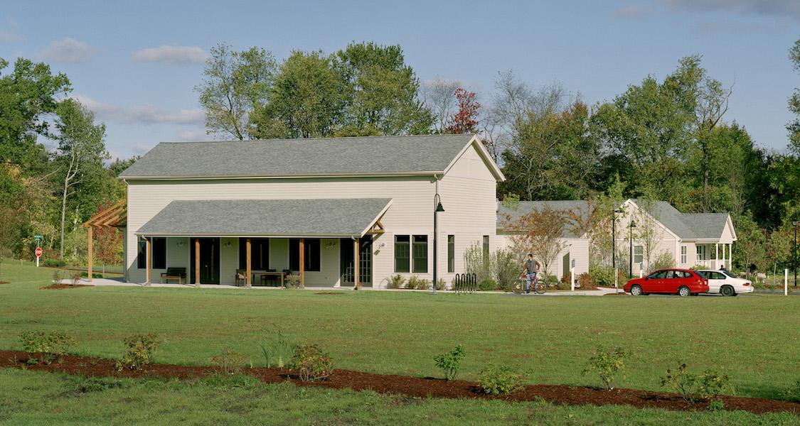 Community building with porch, with lawn in foreground.