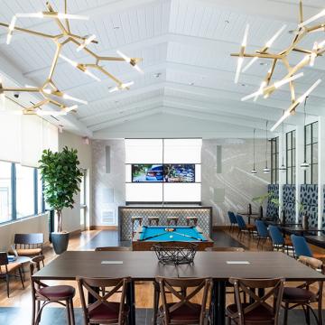 Dining/bar area with pool table and low cathedral ceiling.